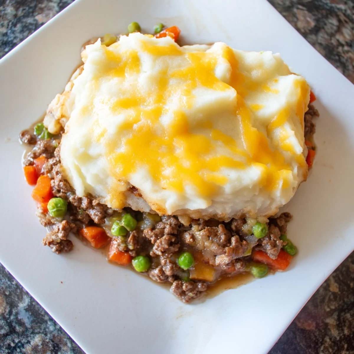 Budget Shepherds Pie steaming hot, with a cheesy mashed potato topping, ready to serve and enjoy.