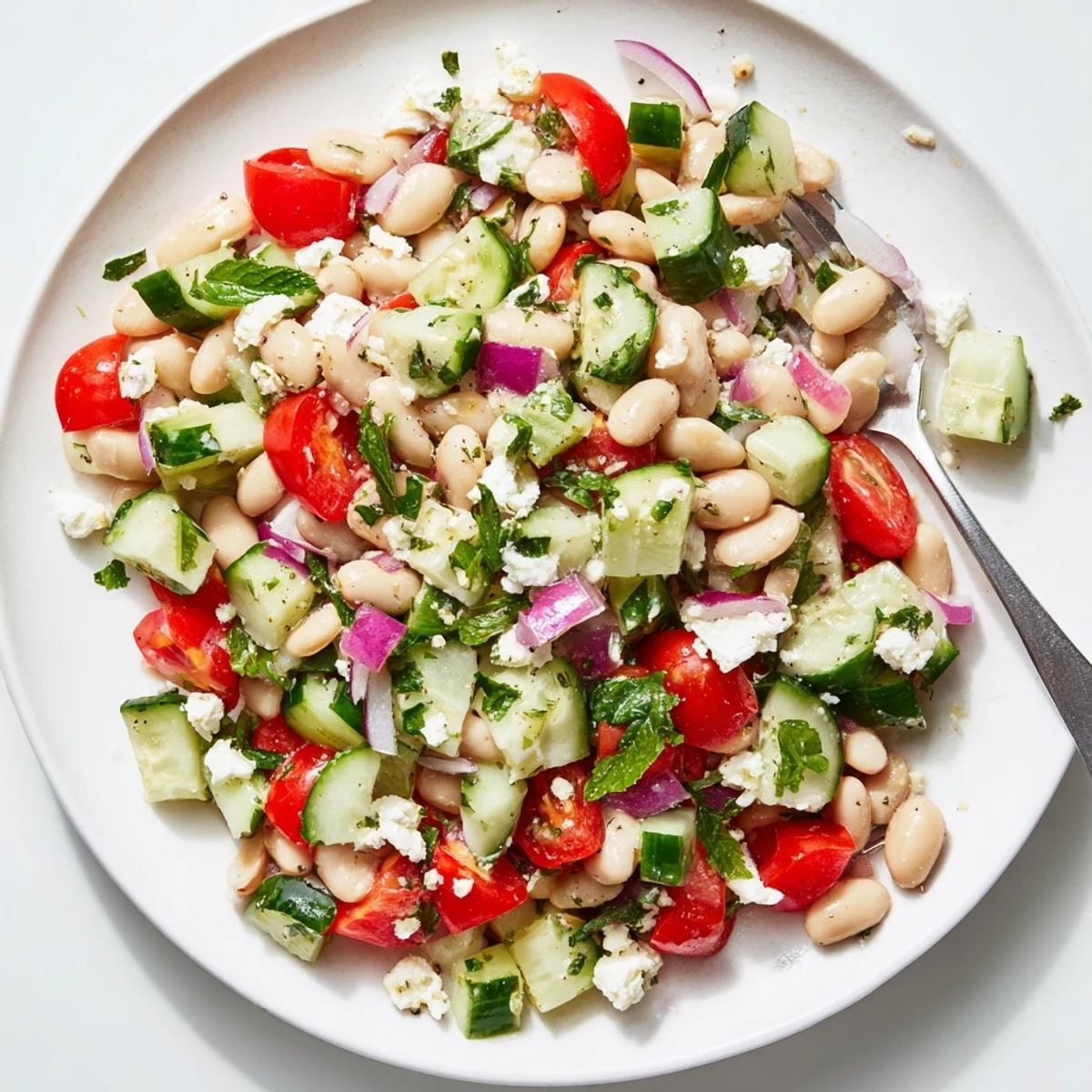 A colorful bowl of Mediterranean White Bean Salad, showing juicy tomatoes and herbs, perfect for a light lunch.