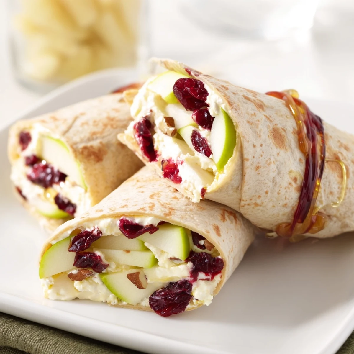 Close-up featuring a sliced Cranberry Goat Cheese & Walnut Holiday Wrap, displaying the creamy cheese and vibrant fillings.