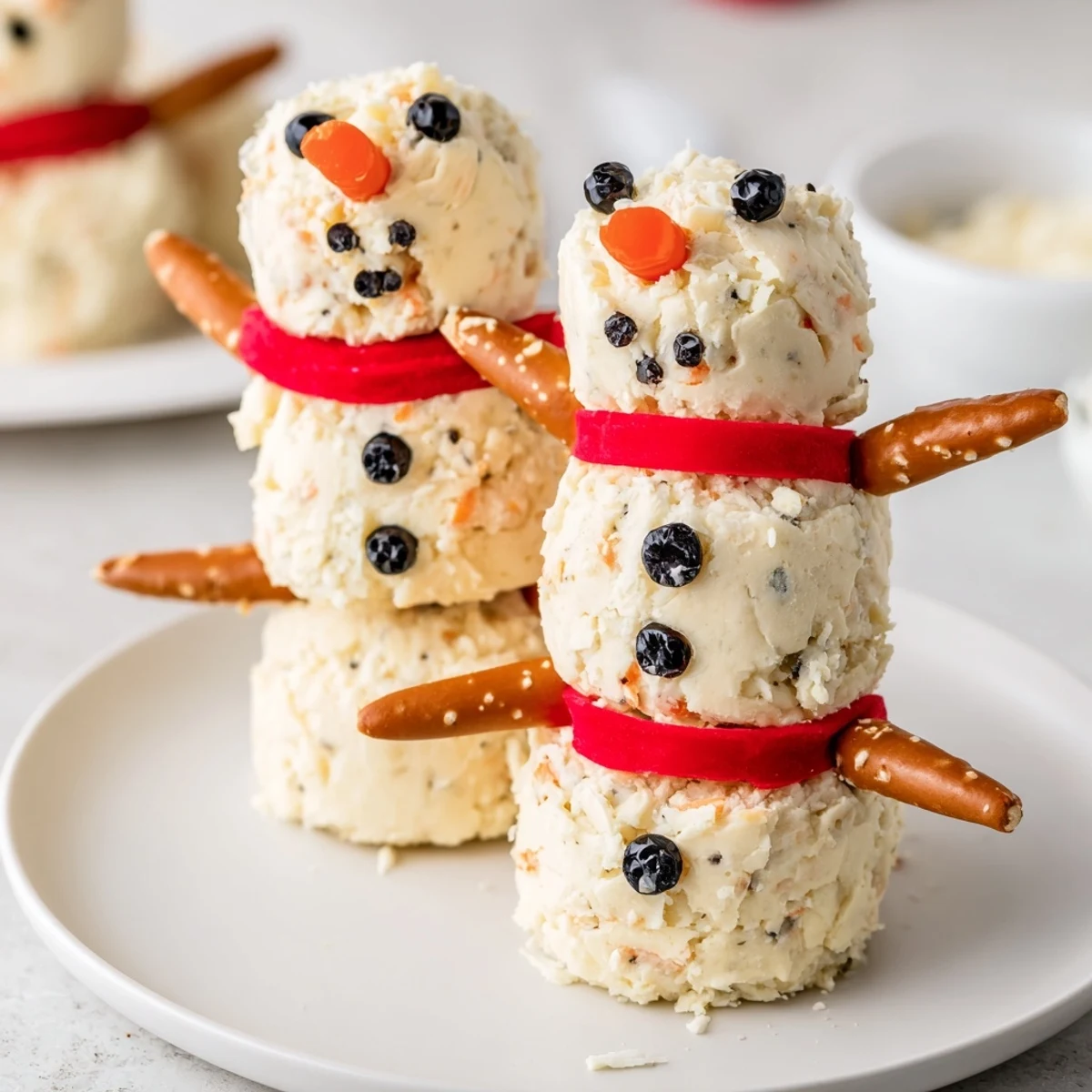 Delightful Snowman Cheese Ball Trio, ready to serve with crackers and veggie dippers, fun for holidays.