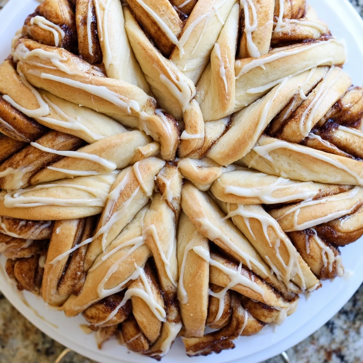 Warm, golden-brown Giant Snowflake Sweet Roll centerpiece, ready to serve with a sweet vanilla icing drizzle.