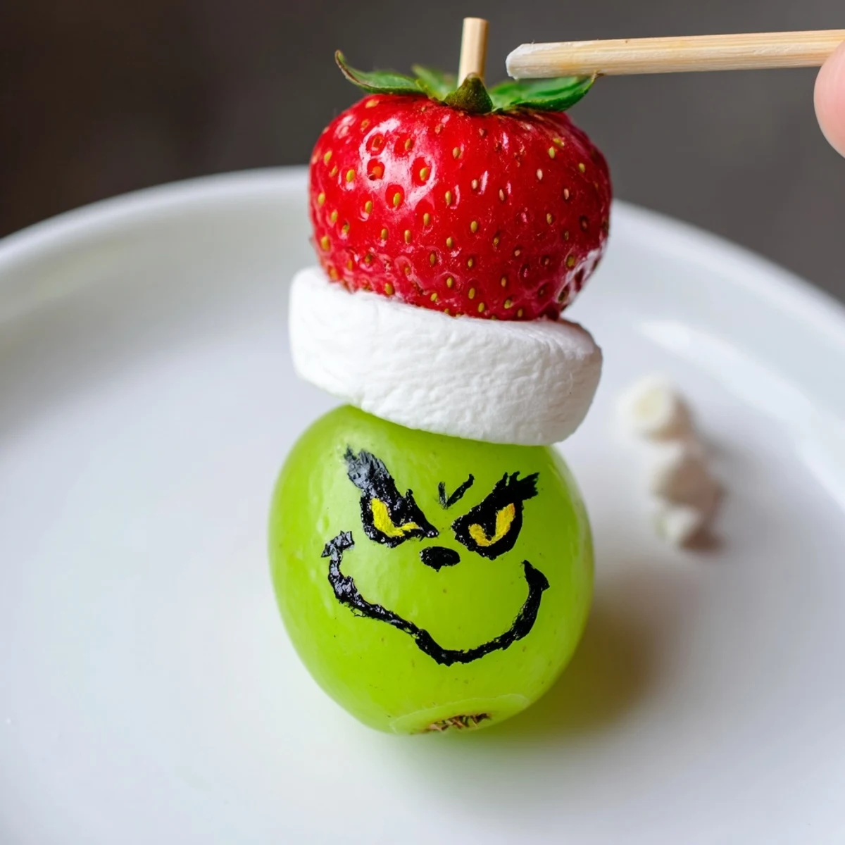 Easy Grinch Snack: Sweet green grapes topped with marshmallow hats, perfect for a kids' holiday party!