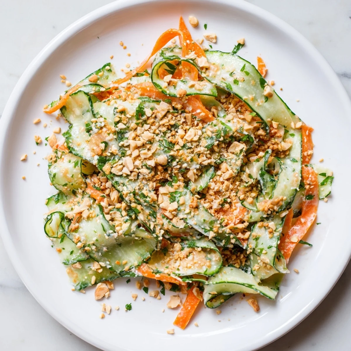 Close-up of a colorful Thai-Style Peanut Cucumber Salad, creamy dressing coating the crispy veggies.