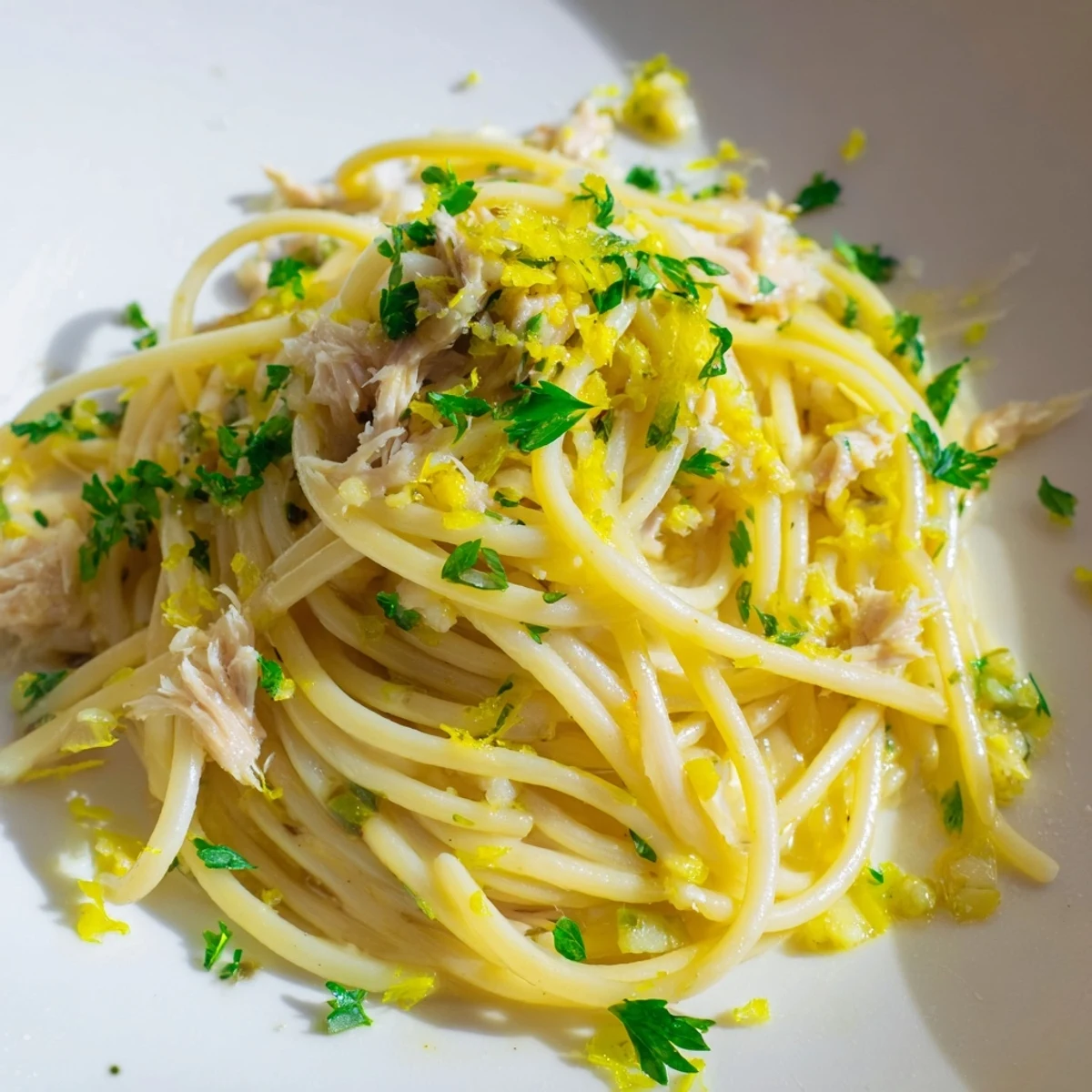 Close-up of Lemon-Garlic Tuna Spaghetti, showcasing the flaky tuna and bright lemon zest atop perfectly cooked pasta.
