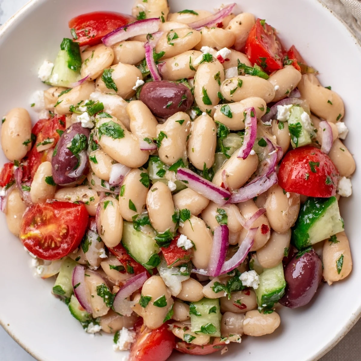 A bright White Bean Salad: displaying a colorful blend of tomatoes, herbs, and beans, tossed in dressing.
