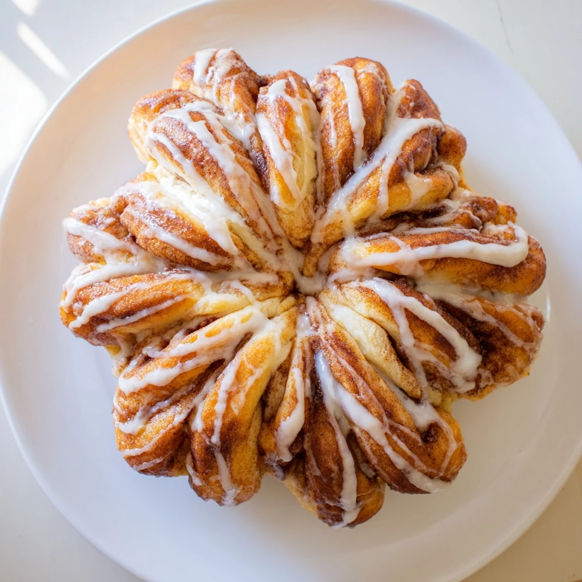 Warm, golden Cinnamon Roll Pull-Apart Snowflake with glistening icing, perfect for a cozy winter breakfast.