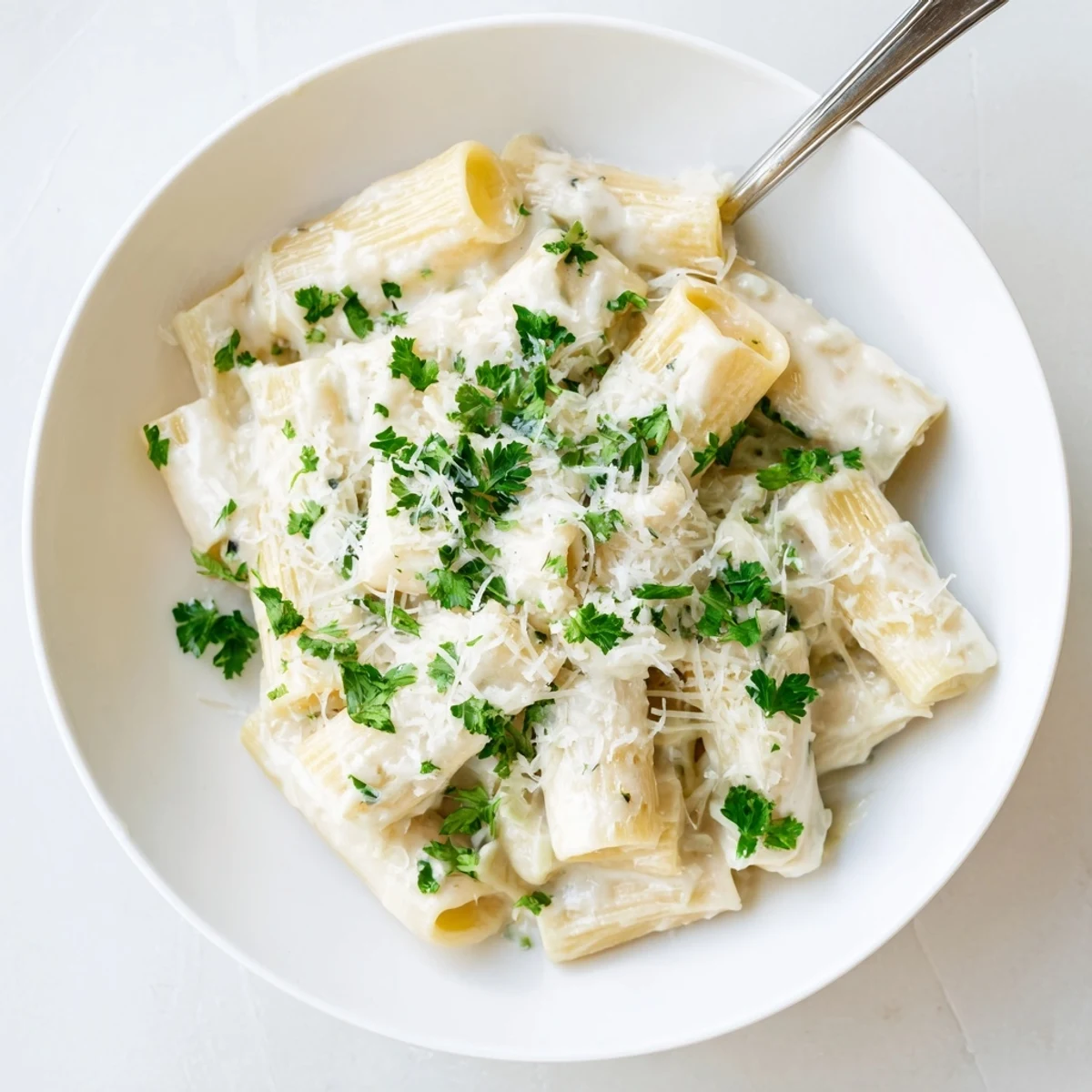 Close-up of Creamy Milk Pasta One-Pot in a saucepan, highlighting tender penne coated in rich, glossy sauce with steam rising.