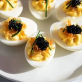 Creamy deviled eggs, showcasing a luxurious caviar topping and golden crispy shallots for texture.