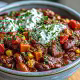 A hearty pot of Black-Eyed Pea Chili simmering with diced bell peppers and corn, offering a vibrant, savory vegetarian dinner option.