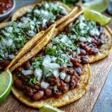 Black-Eyed Pea Tacos served warm with corn tortillas, lime wedges, and a generous spoonful of salsa.