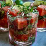 Refreshing watermelon mint spritz with vibrant mint leaves and juicy fruit cubes in chilled glasses.