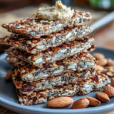 A tray of crunchy seed crackers packed with oats and chia, perfect for pairing with hummus or cheese.