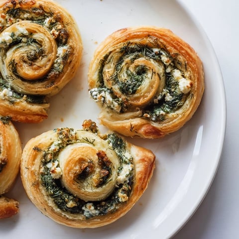 Golden-brown savory spinach feta pinwheel spirals, perfect for a Mediterranean appetizer platter.