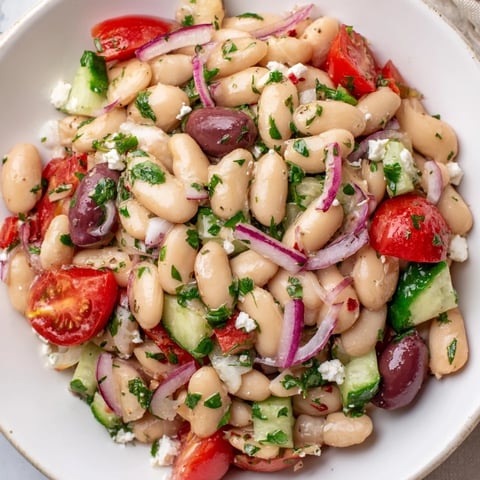 A bright White Bean Salad: displaying a colorful blend of tomatoes, herbs, and beans, tossed in dressing.