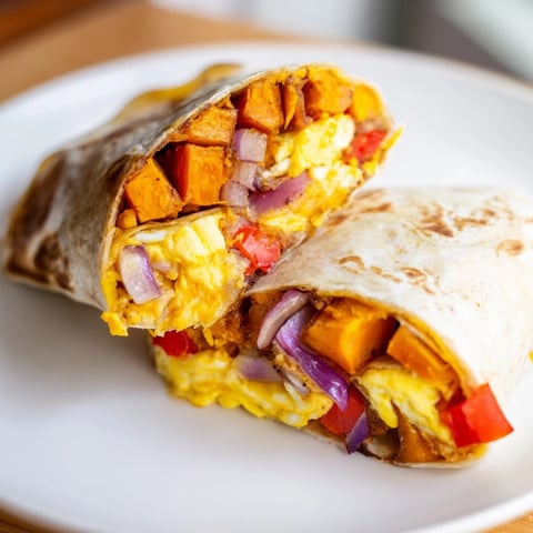 Fluffy scrambled eggs, roasted sweet potatoes, and melty cheese star in these breakfast burritos.