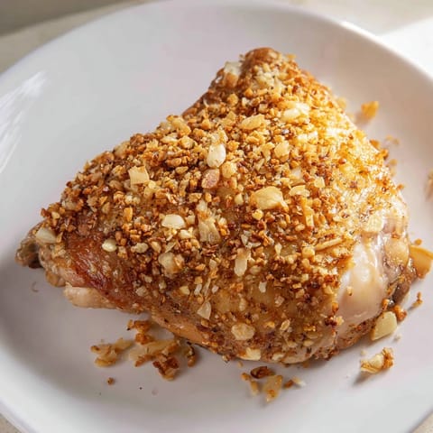 Sizzling close-up view of irresistibly crispy garlic chicken thighs, perfectly roasted for dinner tonight.