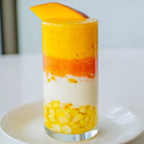 Refreshing Tropical Sunset Smoothie: A layered beauty showing mango, passion fruit, and orange hues.