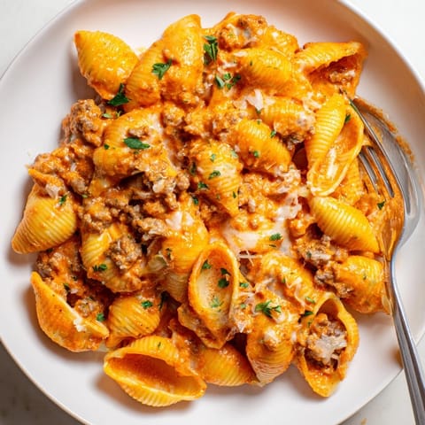 Creamy One Pot Beef and Shells pasta in a skillet, garnished with fresh parsley and melted cheddar, ready for a cozy dinner.
