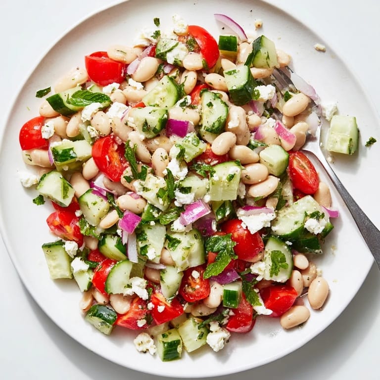 A colorful bowl of Mediterranean White Bean Salad, showing juicy tomatoes and herbs, perfect for a light lunch.