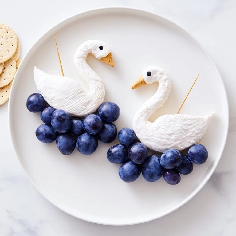 A beautiful Elegant Swan Lake Board with grapes and crackers offers a lovely cheese platter.