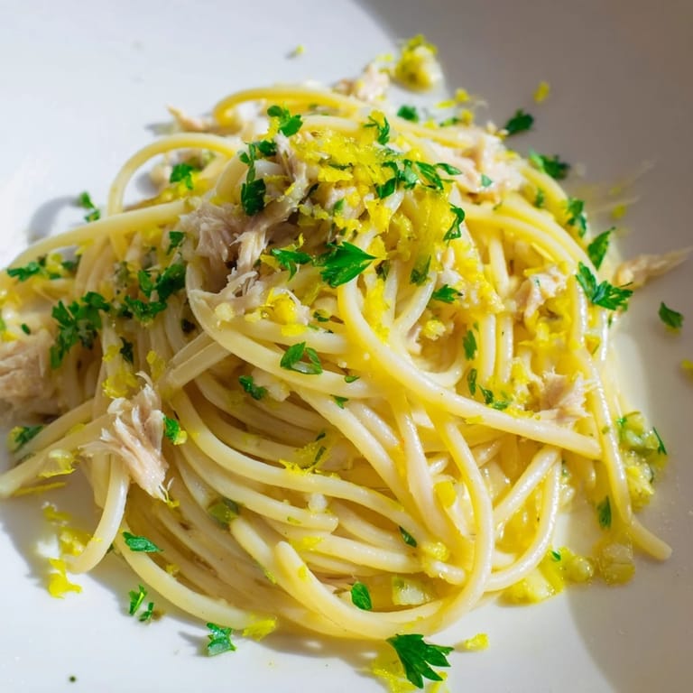 Close-up of Lemon-Garlic Tuna Spaghetti, showcasing the flaky tuna and bright lemon zest atop perfectly cooked pasta.