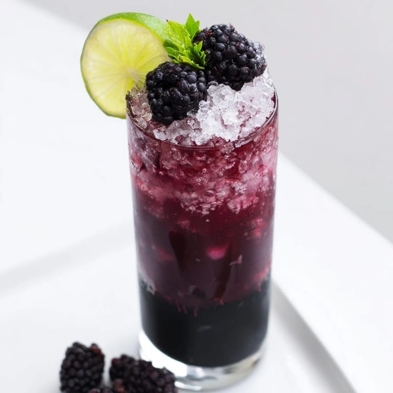 Imagine a visually exciting Dark Matter Mocktail: jet black drink with a vibrant blackberry garnish.