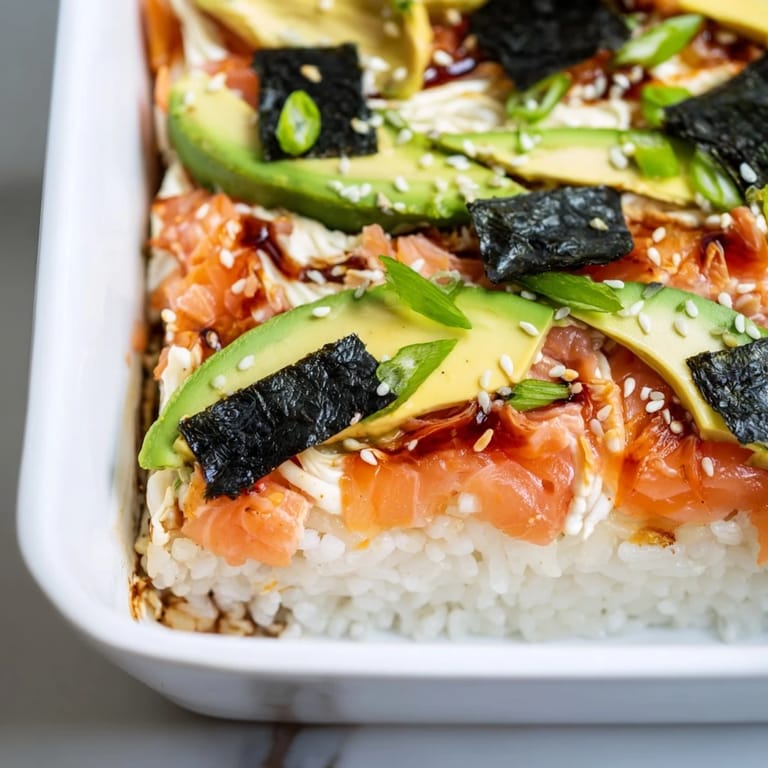 Beautifully baked Sushi Bake casserole, featuring seasoned rice, flaky salmon and a creamy topping, ready to eat.