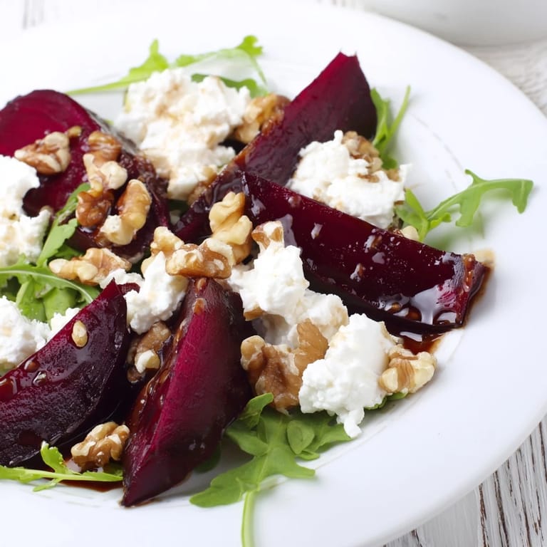 Vibrant Roasted Beet Goat Cheese Salad featuring tender roasted beets, tangy goat cheese, and walnuts over peppery greens.