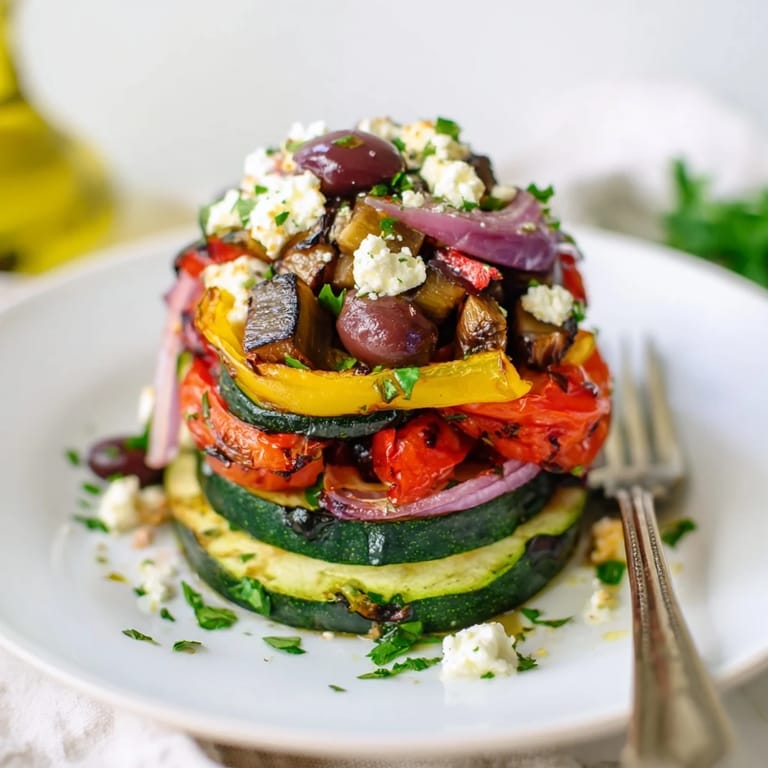 This Roasted Greek Salad features colorful roasted bell peppers, onions, zucchini, and tomatoes with cucumber and olives.