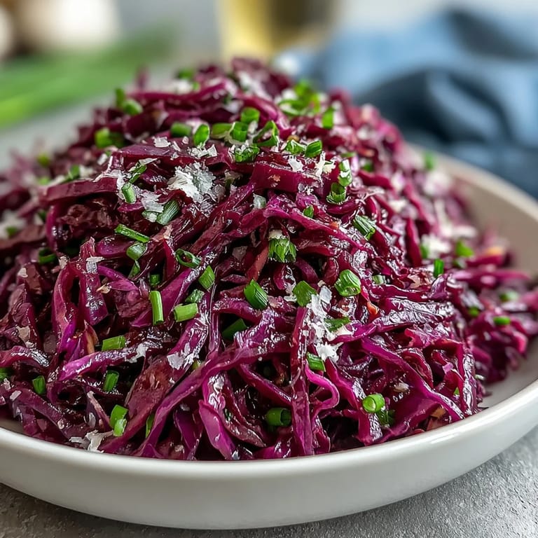 Large bowl of fresh Red Cabbage Coleslaw with Apple and Parmesan, sprinkled with parsley, served as a colorful side dish.