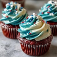 Vibrant Star-Spangled Banner Cupcakes showcase swirled red, white, and blue frosting, perfect for holidays.